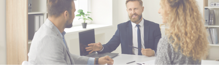 Insurance Broker talking to a couple in an office.