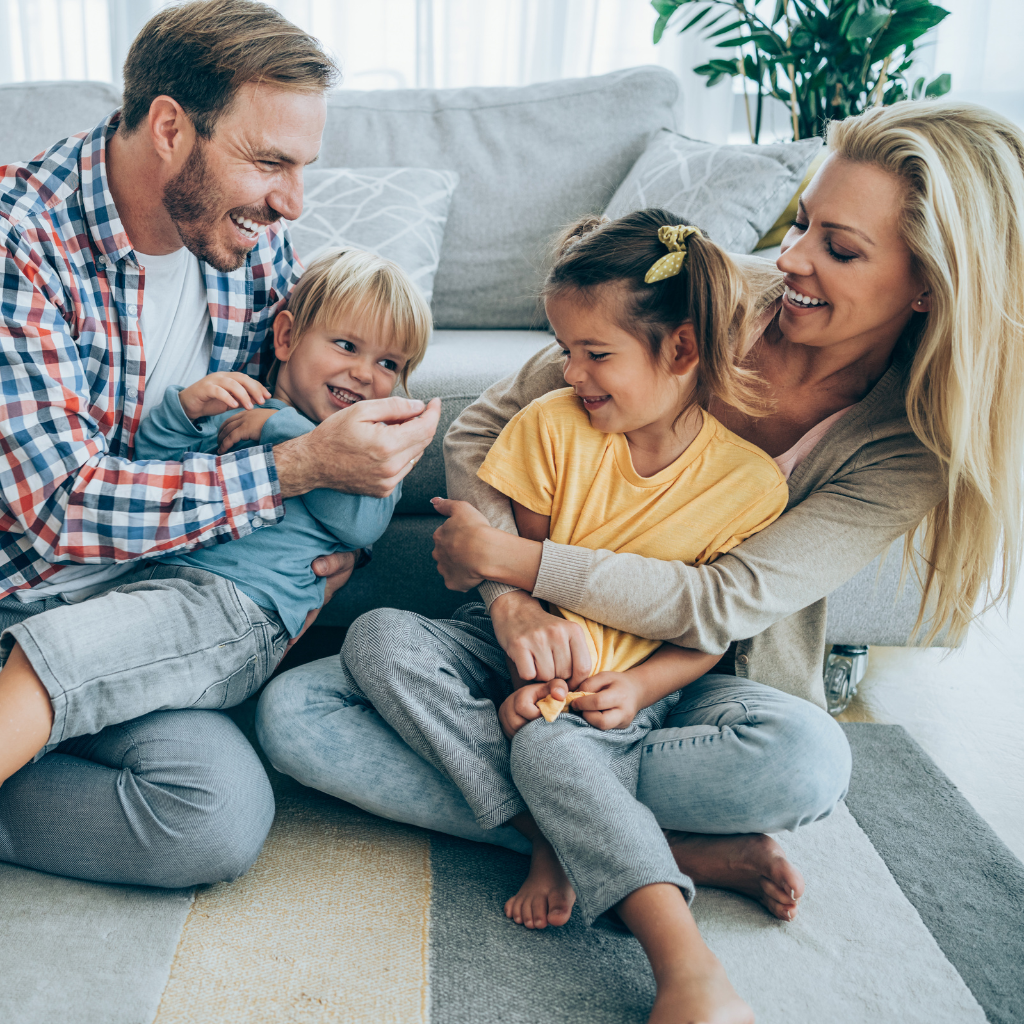 Happy family sitting on the floor in their home